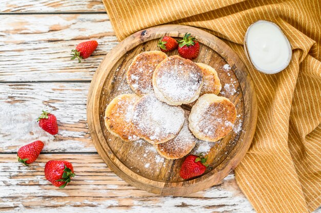 Panqueques de requesón, syrniki, buñuelos de requesón con fresa. Desayuno Gourmet. Vista superior