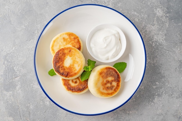 Panqueques de requesón syrniki ricotta buñuelos con miel y crema agria delicioso desayuno