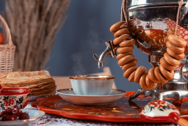 Panqueques rusos blini con taza de té samovar y secado en la mesa shrovetide maslenitsa festival c...