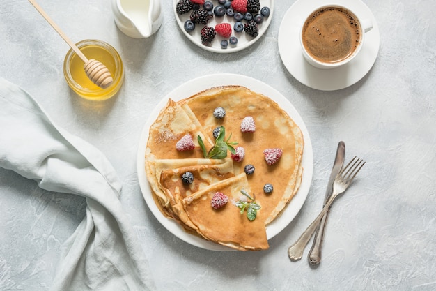 Panqueques rusos con miel, bayas y leche