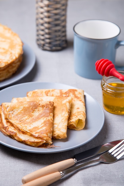 Panqueques rusos tradicionales con miel. Carnestolendas. Semana Maslenitsa. Enfoque selectivo, primer plano.