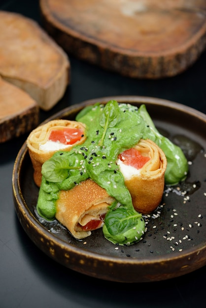 Foto panqueques con salmón pescado, queso y espinacas. menú del restaurante