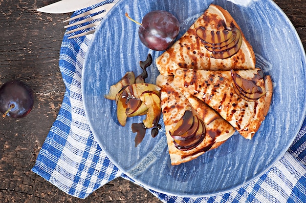 Panqueques con sirope de chocolate y ciruelas