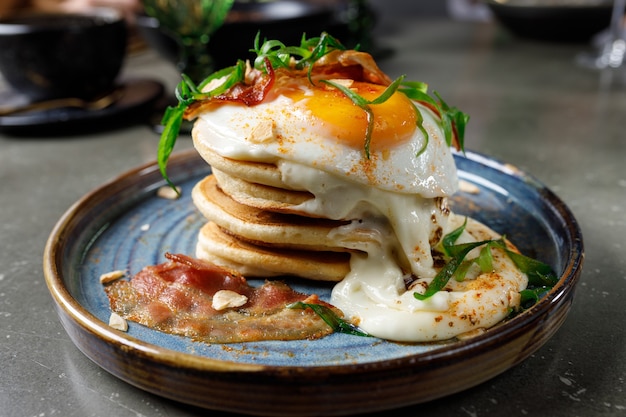 Panqueques con tocino, huevos fritos y queso fundido