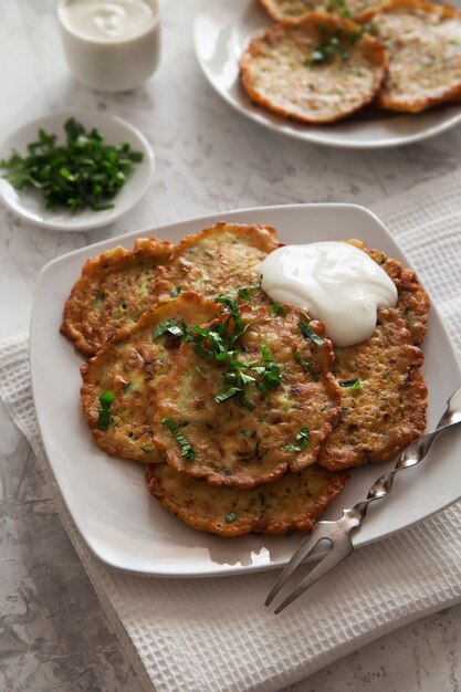 Panqueques de vegetales con crema agria en un plato blanco