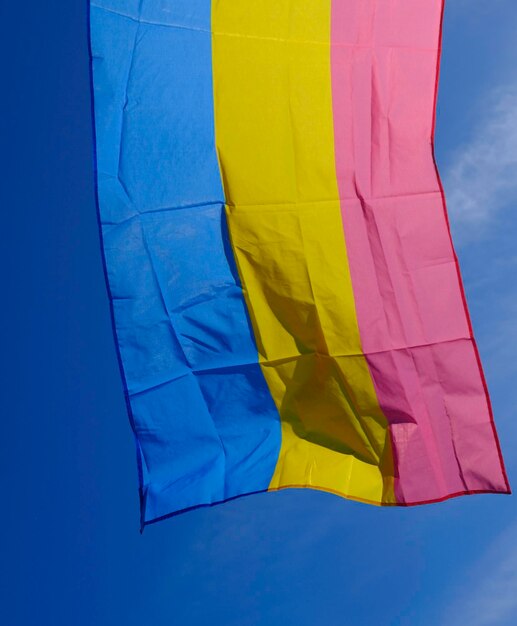 pansexuelle Flagge, die an einem sonnigen Tag im Wind flattert.