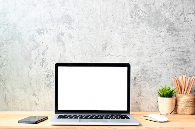 Foto pantalla en blanco computadora portátil moderna con mouse, teléfono inteligente y suculenta en mesa de madera en fondos de vista de oficina