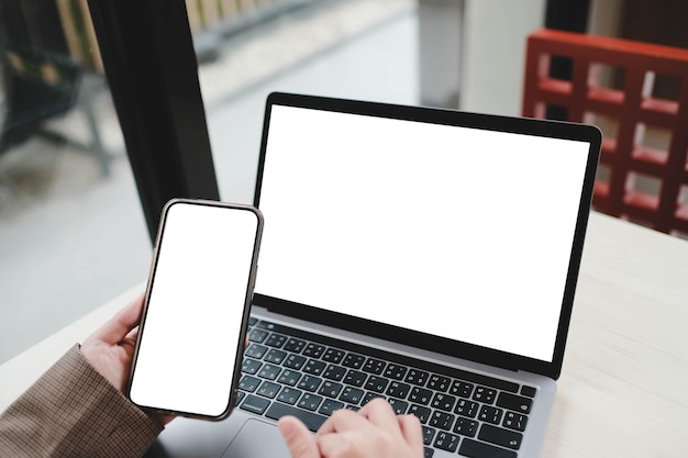 Una pantalla en blanco para escribir textos a mano utilizando computadora portátil y teléfono móvil contacto de negocios búsqueda de información en el lugar de trabajo en el escritorio en la oficina
