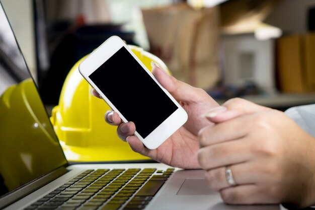 Pantalla en blanco del teléfono inteligente en la mesa de trabajo de ingeniería.