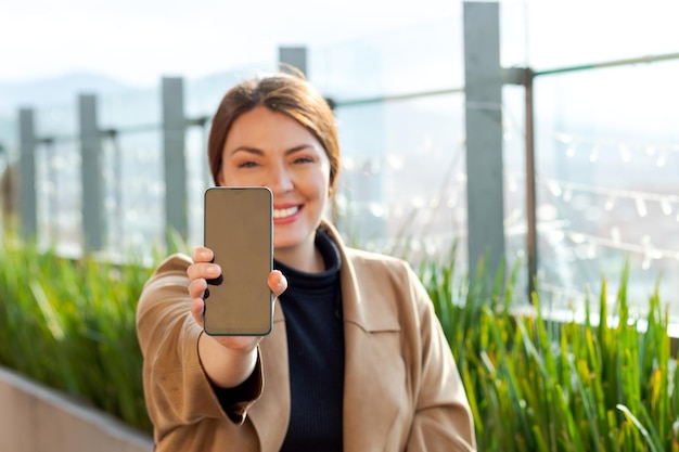 Pantalla de celular en primer plano mujer borrosa en el fondo