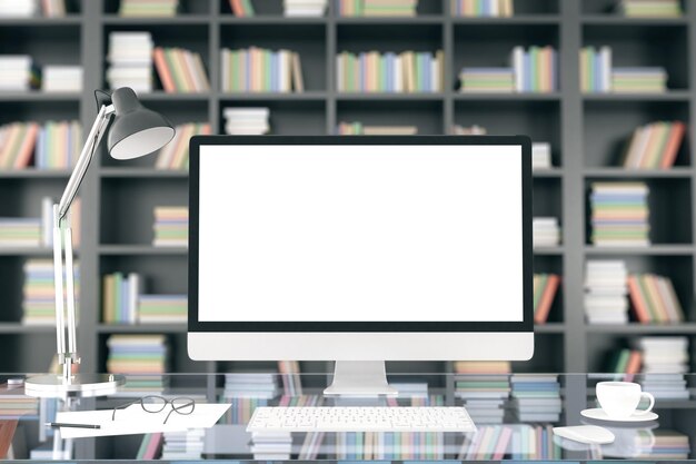 Pantalla de computadora en blanco en la mesa de cristal en el fondo de la estantería maqueta