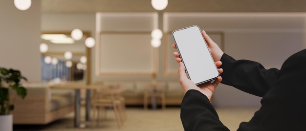 Una pantalla de maqueta de un teléfono inteligente en manos de mujeres sobre fondo de restaurante moderno borroso