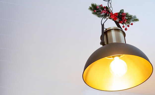 La pantalla negra de estilo loft industrial está decorada con ramas de abeto para Navidad y Año Nuevo en el fondo de guirnaldas de luces de hadas Minimalismo de primer plano