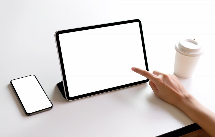 Foto pantalla de tableta y teléfono inteligente en blanco en la maqueta de la mesa para promocionar sus productos.