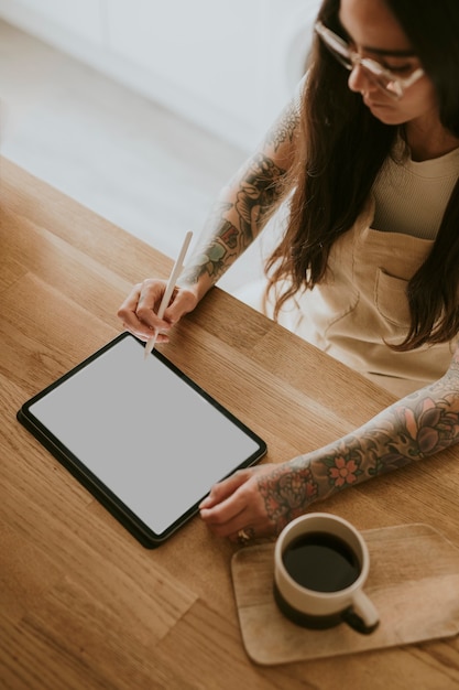 Pantalla de tableta vacía y mujer sosteniendo un lápiz óptico