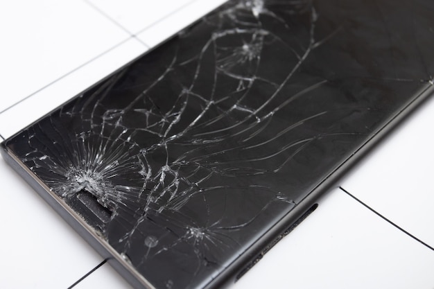 La pantalla de vidrio roto del teléfono inteligente se encuentra en la tableta para su reparación
