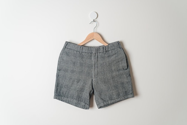 pantalones cortos colgados con un colgador de madera en la pared