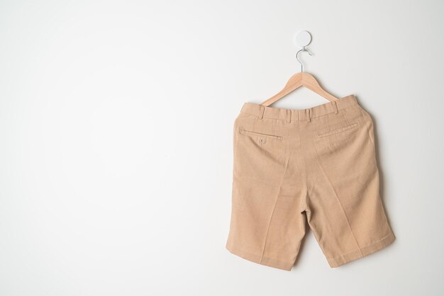 pantalones cortos colgados con un colgador de madera en la pared