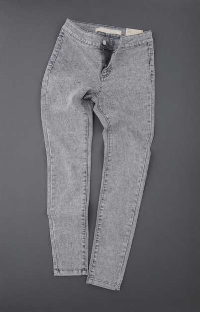 Foto pantalones de mezclilla de moda sobre fondo gris, vista superior