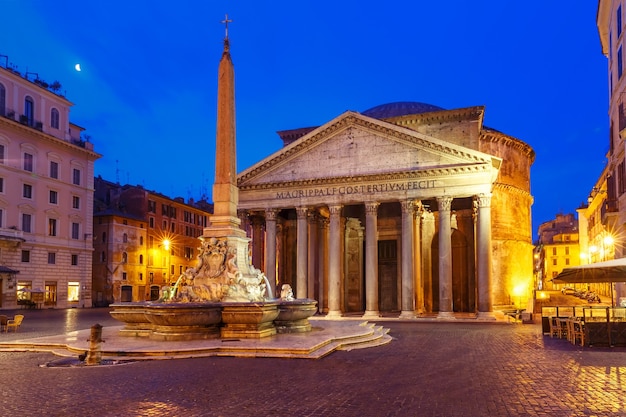 El Panteón, antiguo templo romano de todos los dioses, ahora una iglesia y una fuente con obelisco en la Piazza della Rotonda, por la noche, Roma, Italia