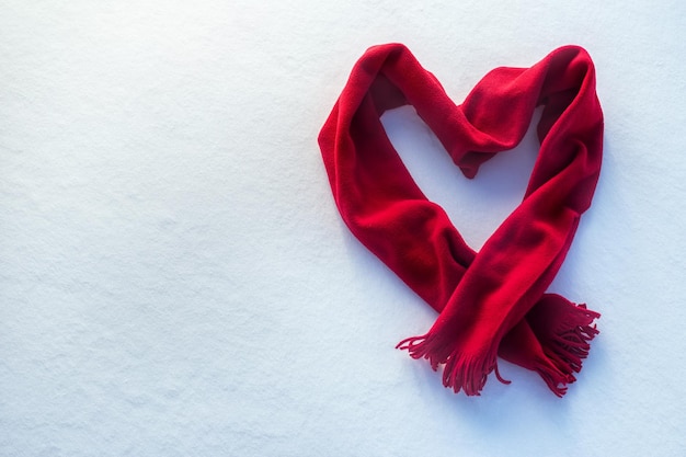 Foto pañuelo rojo como corazón en la nieve