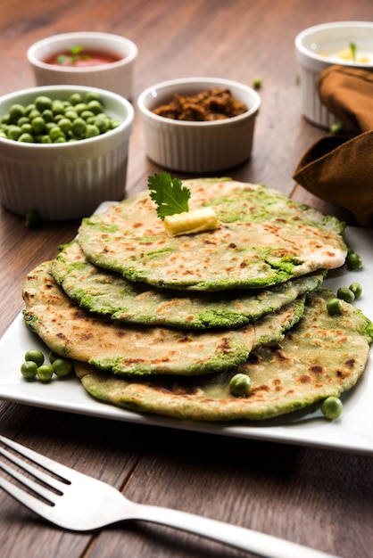 Pão Achatado Recheado de Ervilhas ou Matar ka Paratha é um alimento tradicional do Norte da Índia. servido com picles de manga, sobre fundo sombrio, foco seletivo