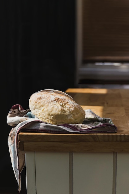 Pão artesanal feito na hora na mesa de madeira na cozinha