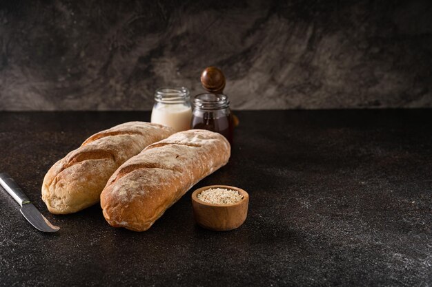 Pão artesanal fresco caseiro de pães de baguete em fundo rústico com espaço para cópia mini fermento