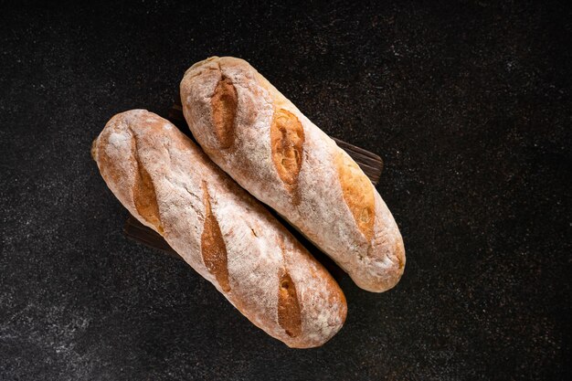 Pão artesanal fresco caseiro de pães de baguete em fundo rústico com espaço para cópia mini fermento