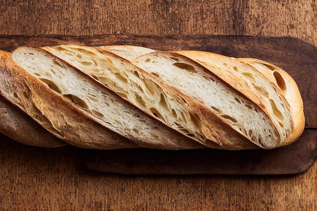 Pão assado de baguete de trigo na mesa de madeira