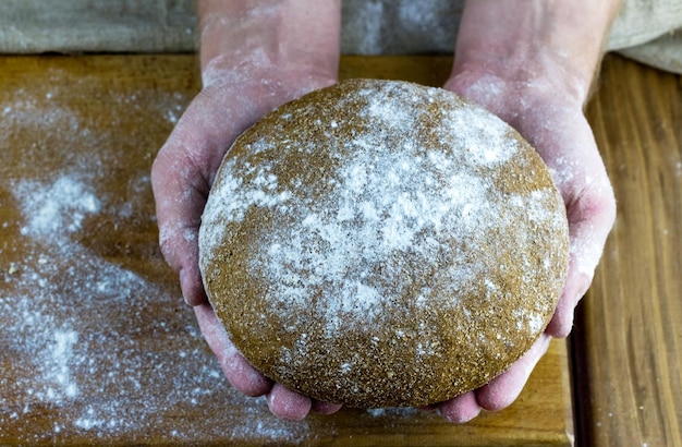 Pão assado em casa nas mãos masculinas