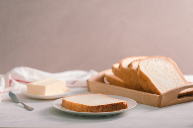 Pão branco fatiado com manteiga filmado de uma vista de alto ângulo