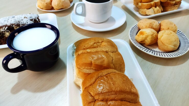 Foto pão brasileiro tradicional conhecido como po doce ou pão doce com uma xícara de café