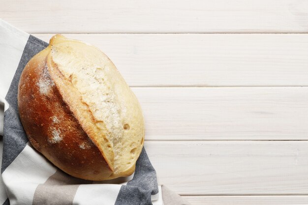 Foto pão caseiro com acessórios de cozinha e ingredientes de panificação em uma mesa de madeira com lugar para texto. padaria fresca.