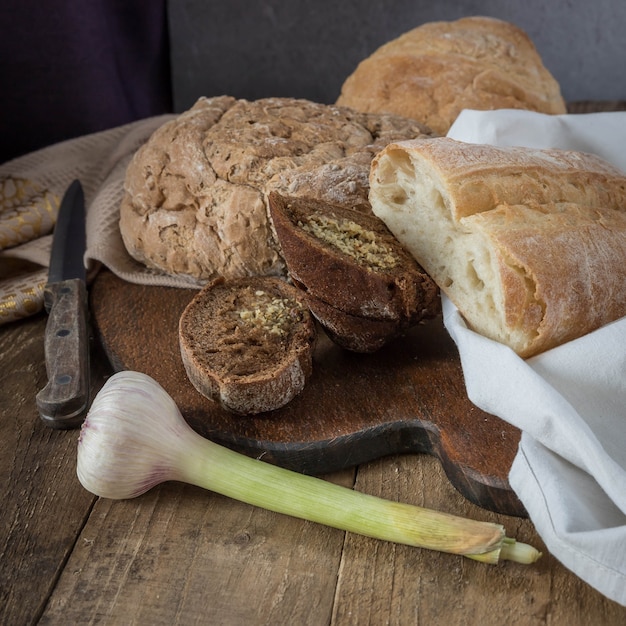 Pão caseiro de alho em um guardanapo bege e mesa de madeira