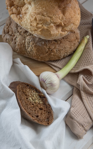 Pão caseiro de alho em um guardanapo bege e mesa de madeira