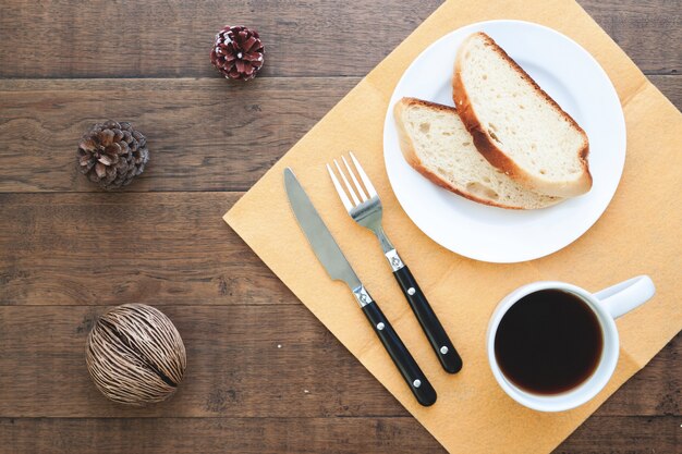 Pão caseiro fatiado com café na mesa de madeira