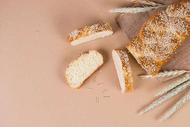 Pão caseiro fresco com sementes de gergelim na padaria, um conceito moderno na parede bege pastel, vista superior, copie o espaço