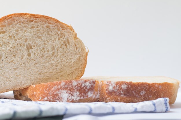 Pão caseiro fresco no fundo branco da tabela com guardanapo