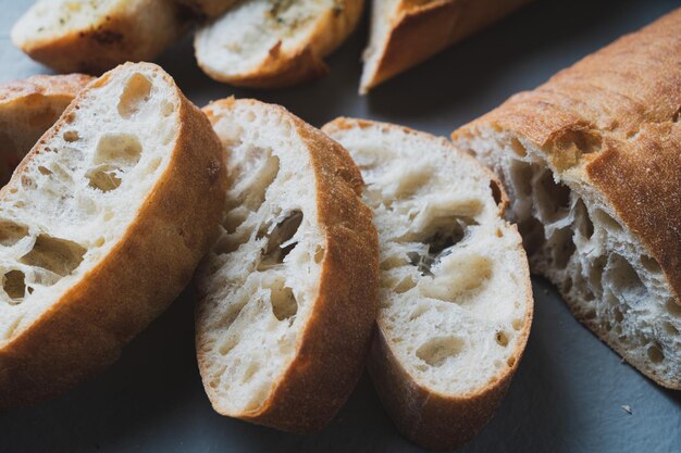 Pão caseiro recém-assado com crosta crocante em fundo cinza