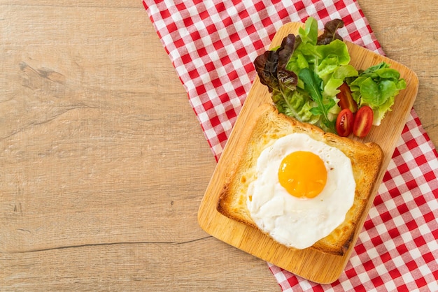 pão caseiro torrado com queijo e ovo frito por cima com salada de vegetais no café da manhã