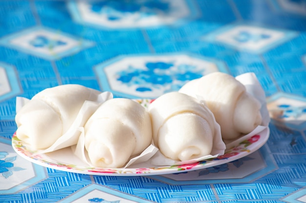 Pão chinês cozido no vapor ou mantou em um prato na mesa.