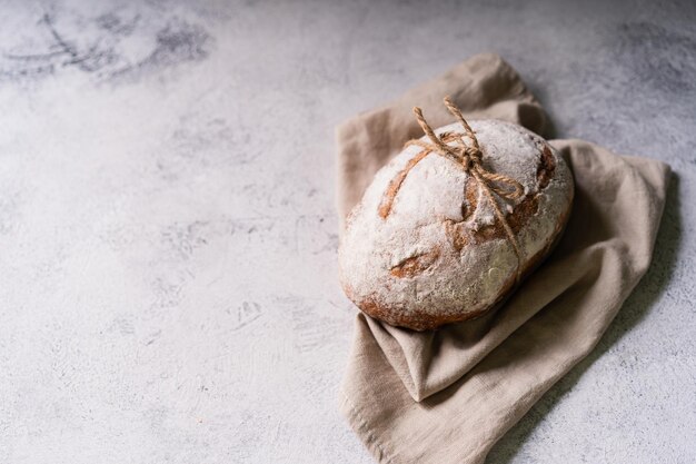 Pão ciabatta caseiro orgânico fresco com azeite de ervas e azeitonas em fundo rústico branco