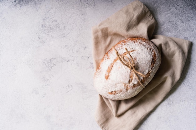 Pão ciabatta caseiro orgânico fresco com azeite de ervas e azeitonas em fundo rústico branco