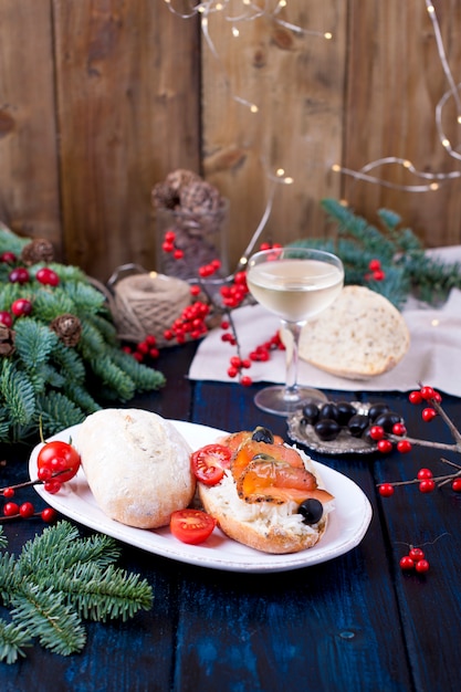 Pão com arroz peixe vermelho, um copo de vinho branco, uma árvore de natal