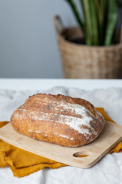 Pão com crosta crocante é lindo e apetitoso pão delicioso repousa sobre uma tábua de madeira