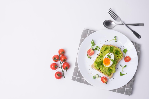 Pão com frutas e ovos de abacate no fundo branco Conceito de café da manhã saudável