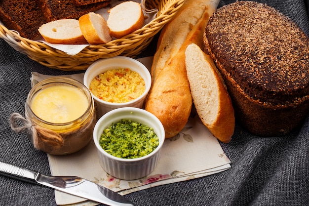 Pão com manteiga no fundo cinza. pão em uma cesta em um fundo cinza