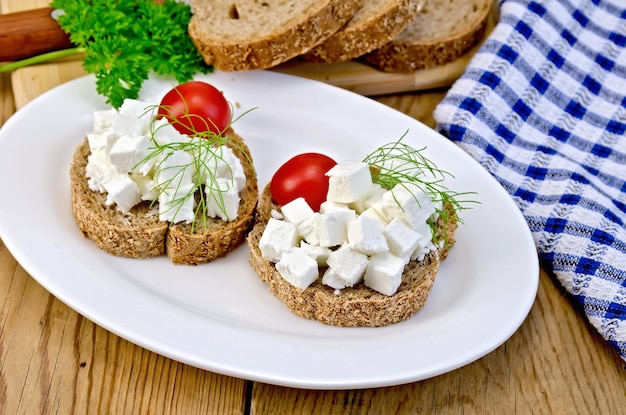 Pão com queijo feta e tomate no prato a bordo