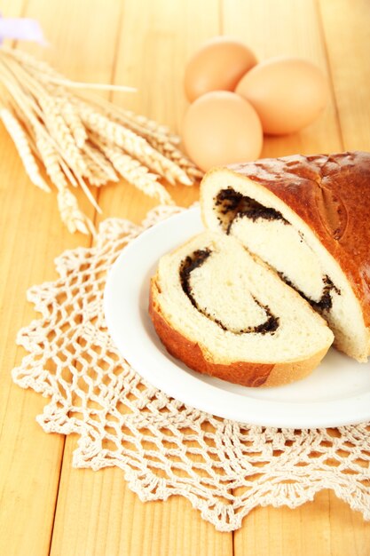 Pão com sementes de papoula na chapa colorida, em madeira